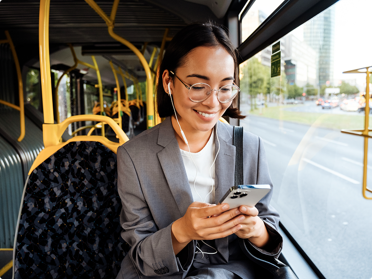 Lady sitting on a bus using her mobile phone