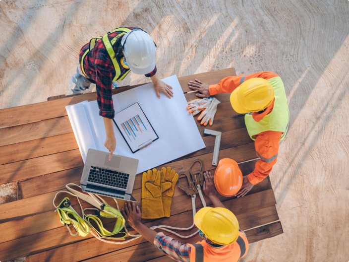 Photo overhead of tradies working at a table